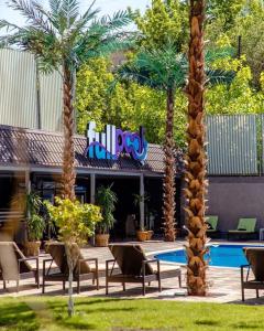 un complejo con palmeras y piscina en Colette Hotel en Ereván