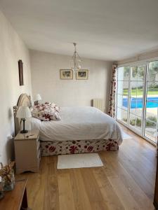 ein Schlafzimmer mit einem Bett und einem großen Fenster in der Unterkunft Chalet Ciudad Ducal con piscina y jardin in El Puerto de Santa María