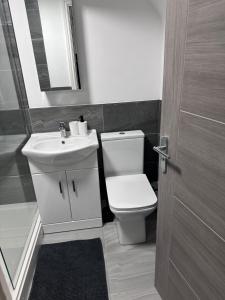 y baño con aseo blanco y lavamanos. en Stunning 2-flat in Leicester!, en Leicester