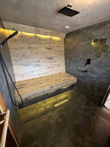 a shower with a wooden bench in a room at Dobri Dom in Almaty