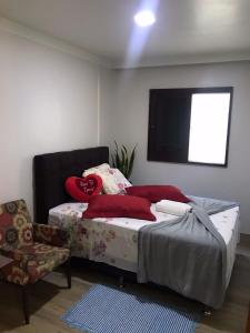 Schlafzimmer mit einem Bett und einem Flachbild-TV in der Unterkunft Casa Aconchego dos Canyons in Praia Grande