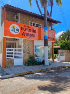 una tienda con un letrero naranja al lado de un edificio en Pousada Porto de Amigos, en Porto de Galinhas