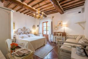 1 dormitorio con 1 cama, mesa y sillas en Mulino Di Quercegrossa, en Quercegrossa