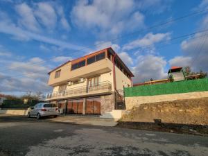 a house with a car parked in front of it at Къща за гости Люляк in Lyulyakovo