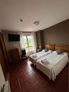 a bedroom with a large bed and a television at Hotel Restaurante el Fornon in Novellana