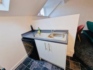 - une petite cuisine avec évier dans la chambre dans l'établissement 1Bed Downtown Apt near Anfield Stadium, à Liverpool