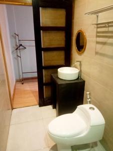 La salle de bains est pourvue de toilettes blanches et d'un lavabo. dans l'établissement Tantra Hotel, à Krui