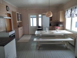 uma cozinha com uma mesa branca num quarto em Omakotitalo maaseudulla lähellä Lahtea em Orimattila