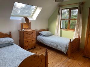 萊特弗拉克的住宿－BunkHouse - Letterfrack Farm，一间卧室设有两张单人床和一个窗户。
