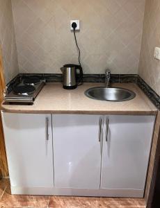 - un comptoir de cuisine avec évier et pot dans l'établissement شقة الغامدي, à Al Jāmi‘ah