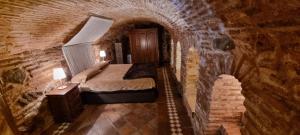 a bedroom with a bed in a brick wall at Cueva árabe en el casco antiguo, Toledo in Toledo