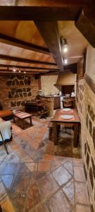 a kitchen with a wooden table and a stone wall at Cueva árabe en el casco antiguo, Toledo in Toledo
