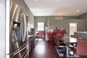 a kitchen with a stainless steel refrigerator and a table at Architectural Gem La Jolla Oceanview Surf And Golf in San Diego