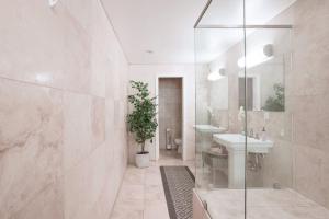 uma casa de banho com um chuveiro, um lavatório e um espelho. em Architectural Gem La Jolla Oceanview Surf And Golf em San Diego