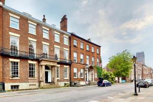 a brick building on a street with cars parked in front at City Central Georgian House with Parking in Liverpool