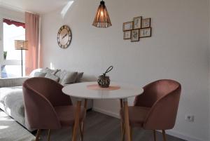 a living room with a table and chairs and a couch at Schwieberdinger Sonnenterrassen-Wohnung in Schwieberdingen