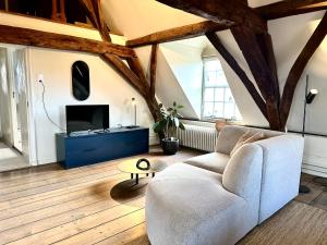 a living room with a couch and a tv at HARBOR HOUSE ZEELAND - nl in Goes
