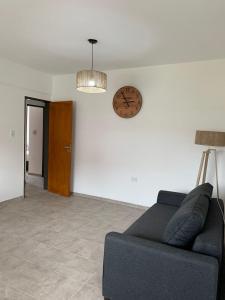 a living room with a couch and a clock on the wall at Housing center in Jesús María