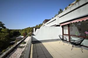 a patio with two chairs and a table on a building at Schwieberdinger Sonnenterrassen-Wohnung in Schwieberdingen