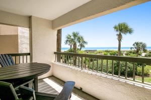 a balcony with a table and chairs and the ocean at Amelia Surf and Racquet in Fernandina Beach