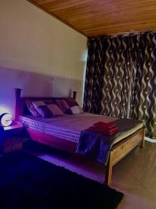 una camera con letto e luce viola di Hakuna matata house a Kigali