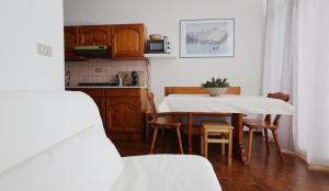 una cucina e una sala da pranzo con tavolo e sedie di Mountain Apartment Rododendro a Tarvisio