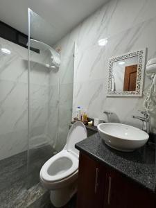 een badkamer met een wit toilet en een wastafel bij GALASUITES in Puerto Baquerizo Moreno