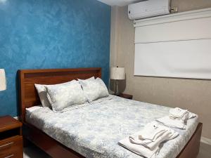een slaapkamer met een bed met een blauwe muur bij GALASUITES in Puerto Baquerizo Moreno