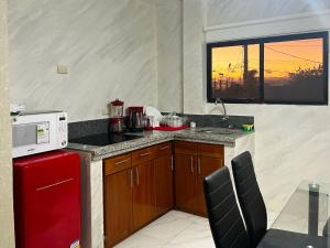 een keuken met een rode koelkast en een magnetron bij GALASUITES in Puerto Baquerizo Moreno