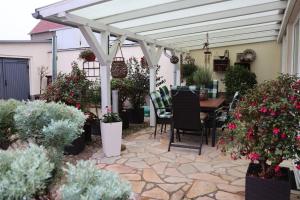 un patio con una mesa y una pérgola blanca en Pension Dürkop, en Havelberg