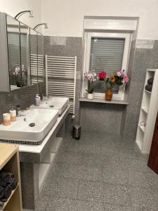 a bathroom with two sinks and a mirror at Anka´s Ferienhaus in Bexbach