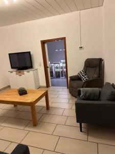 sala de estar con sofá, mesa y TV en Anka´s Ferienhaus, en Bexbach