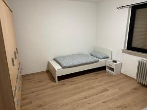 Anka´s Ferienhaus في Bexbach: غرفة نوم صغيرة بها سرير ونافذة