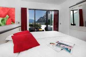 a bedroom with a white bed with a red pillow at Agritur Acetaia Gourmet&Relax in Tenno