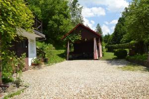a barn with a gravel driveway next to a building at Apartament Pod Piórkiem in Krościenko