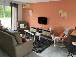 un soggiorno con divano e TV di LA VREMONTOISE a Mâcon