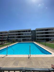 a large swimming pool in front of a building at Acogedor departamento arica in Arica