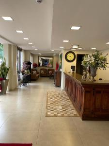 a large lobby with a clock on the wall at Hotel São Luiz in São Gabriel