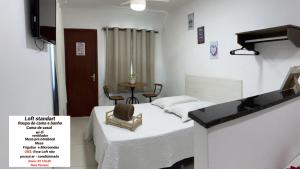 1 dormitorio con 1 cama y 1 mesa con silla en Loft Casa Feliz, en Rio das Ostras