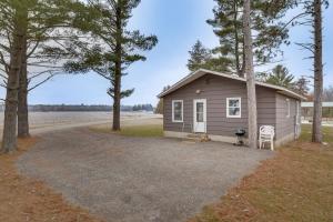 a small house with two chairs and a driveway at Pet-Friendly Cabin Retreat Wisconsin River Access in Lyndon Station