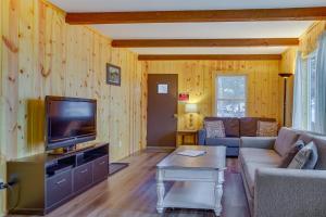 a living room with a couch and a tv at Pet-Friendly Cabin Retreat Wisconsin River Access in Lyndon Station