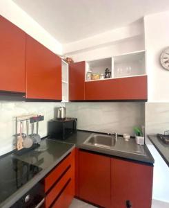 una cocina con armarios rojos y fregadero en Holiday apartment, en Durrës