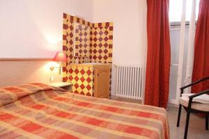 - une chambre avec un lit et un mur en damier dans l'établissement LE COMPTOIR, à Sainte-Croix-de-Verdon