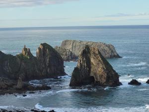 a group of large rocks in the ocean at Hotel Restaurante el Fornon in Novellana