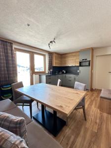 uma sala de estar com uma mesa de madeira e uma cozinha em Bergdiamant Nauders em Nauders