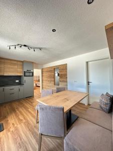 uma cozinha e sala de jantar com uma mesa de madeira e cadeiras em Bergdiamant Nauders em Nauders