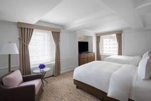 a bedroom with a large white bed and a chair at The Ritz-Carlton New York, Central Park in New York