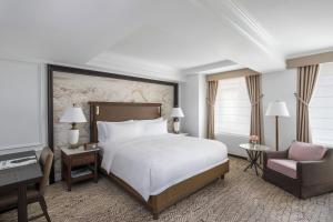 a bedroom with a large bed and a chair at The Ritz-Carlton New York, Central Park in New York