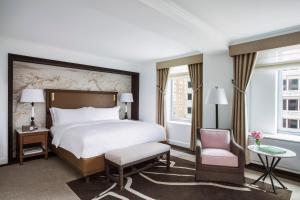 a hotel room with a bed and a chair at The Ritz-Carlton New York, Central Park in New York