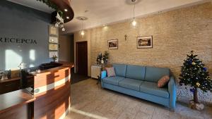 Un vestíbulo con un sofá azul y un árbol de Navidad. en Pensjonat Crosna SPA, en Krościenko nad Dunajcem 68 fotos más